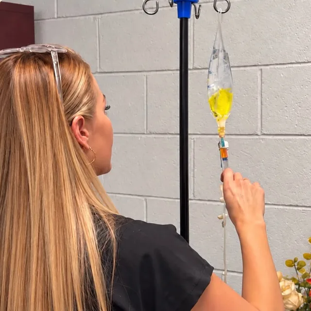 Berenice, RN, setting up an IV drip